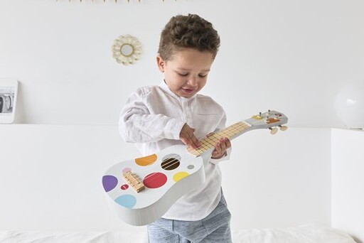 Niño pequeño tocando una guitarra de juguete